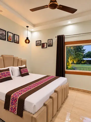 Bedroom two with a window facing the lawn at Mulberry Farm, Noida