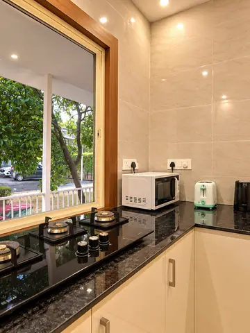 Granite-counter kitchen inside the farmhouse at Mulberry Farm, Noida