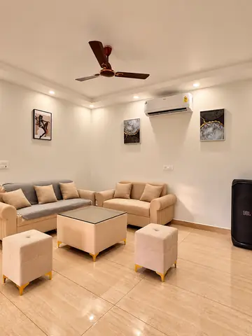 Sofas in the air-conditioned living room at Mulberry Farm, Noida