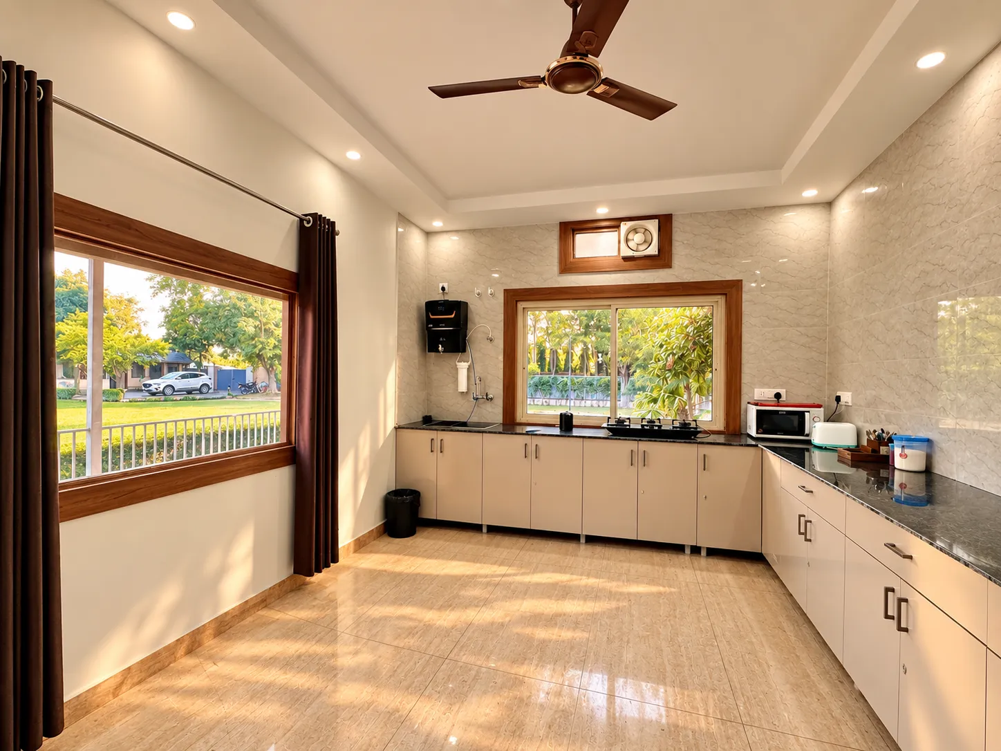 The kitchen at Mulberry Farm — long granite counters and a window onto the garden, Sector 135 Noida